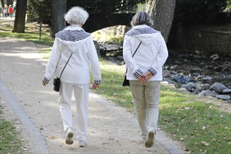 Two pensioners wearing identical jackets during a walk in the park, Bad Harzburg, 06.10.2018