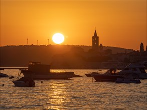 Boats anchoring in a bay, silhouette of a church tower, sunset over Rab, town of Rab, island of