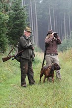 Huntsman and huntress, accompanied by hunting dog Bavarian Mountain Hound, Allgaeu, Bavaria,