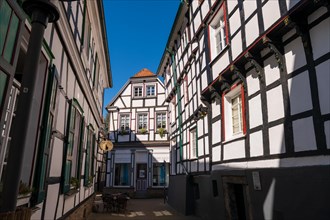 View of a quiet cafe between half-timbered houses on a sunny day, Old Town, Hattingen, Ennepe-Ruhr