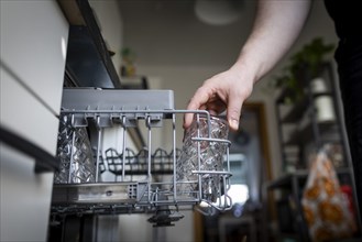 A man loads a dishwasher. Berlin, 08.03.2024
