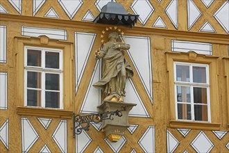 Madonna figure with halo on a yellow half-timbered house, detail, house wall, window, yellow, main
