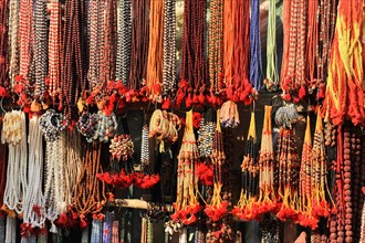 Colourful necklaces and beads hanging in a market stall, presented for sale, Varanasi, Uttar