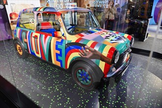 A Mini Cooper with a colourful design and handprints on the bonnet, BMW WELT, Munich, Germany,