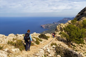Hikers on a mountain path with panoramic views of the sea and coastline, Hiking tour in Taix
