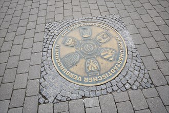 Medallion and memorial plaque to twin towns, inscription, mayor, solidarity, round, floor, town