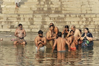 People engage in social interactions while bathing in water, Varanasi, Uttar Pradesh, India, Asia
