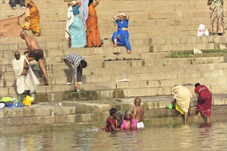 People bathing and washing on the river bank, immersed in the cultural routine, Varanasi, Uttar