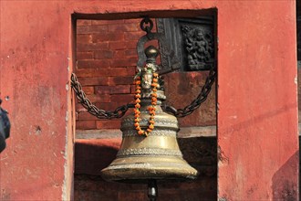 Large bell with floral decorations and religious ornaments on a ghat in Varanasi, Varanasi, Uttar