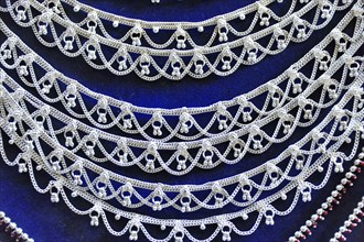 Silver jewellery necklaces with detailed patterns on a dark background, Varanasi, Uttar Pradesh,