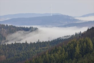 Landscape in the Black Forest with fog, some morning sun and wooded hills near Schuttertal,