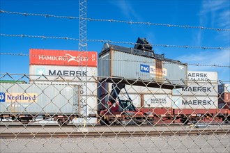 Loading of containers on railway wagons with a lifting crane at a railway depot
