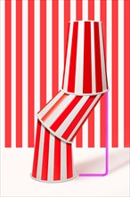 Three red striped drinking cups stacked inside each other with straw
