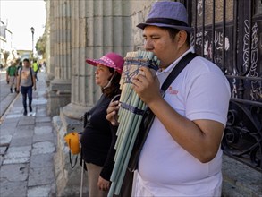 Oaxaca, Mexico, A man plays the pan pipes, while a blind woman collects tips. They are on the