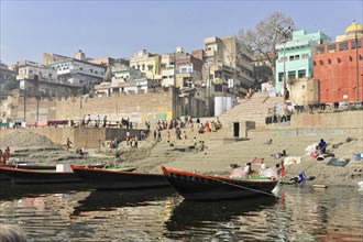 Human life and boats along a sandy riverbank, Varanasi, Uttar Pradesh, India, Asia