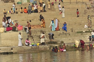 An everyday scenario of people bathing and interacting on a riverbank, Varanasi, Uttar Pradesh,