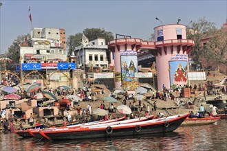 People on boats near ghats with paintings and traditional architecture, Varanasi, Uttar Pradesh,