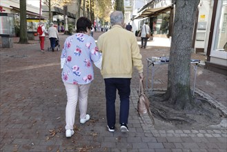 Arm in arm a couple of pensioners walk in the shopping street of Bad Harzburg, 06.10.2018