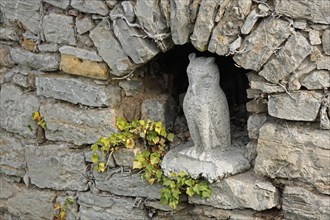 Sculpture of a little owl in a niche of the historic town wall, owl figure, detail, town