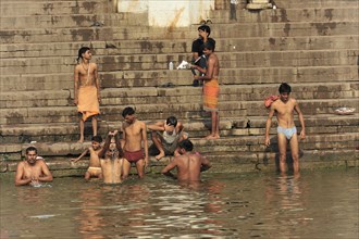 People performing ritual bathing and social interactions at the ghats of a river, Varanasi, Uttar