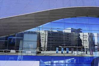 Glass facade of a modern building that reflects the surrounding structures, BMW WELT, Munich,