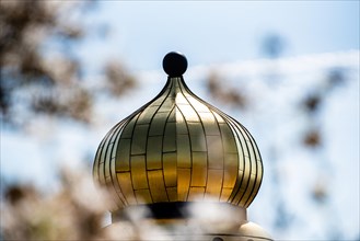Close-up of a shiny golden dome with the sky in the background, Hundertwasser Kindergarten,