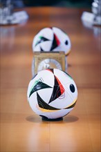 Two footballs lie on the cabinet table during a cabinet meeting at the Federal Chancellery in