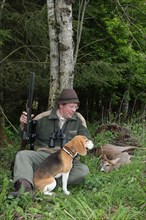 Hunter with hunting dog Beagle next to an abnormal european roe deer (Capreolus capreolus) Allgaeu,