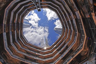 View of the sky and skyscraper spires inside The Vessel, Hudson Yards, Chelsea neighbourhood, West