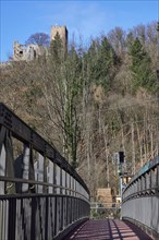 Bridge over the Elz river and the ruins of Kastelburg castle with winter trees in Waldkirch,