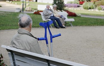 A pensioner with a walking aid sits on a bench in a park in Bad Harzburg, 06/10/2018
