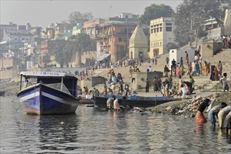 Boat on the riverbank with city view and people in everyday life, Varanasi, Uttar Pradesh, India,