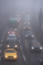Cars driving on a foggy road with poor visibility in the grey daylight, Magdeburg, Saxony-Anhalt,