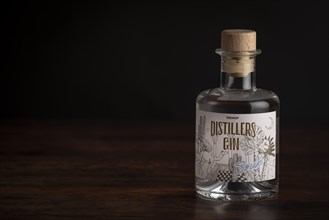 Bottle of gin on a dark wooden table with soft lighting