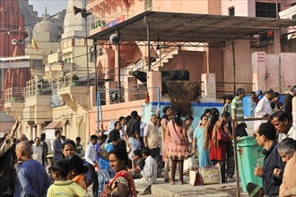 Group of people waiting in a queue on the street next to city buildings, Varanasi, Uttar Pradesh,