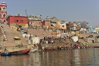 Lively riverside promenade with crowds and traditional buildings, Varanasi, Uttar Pradesh, India,