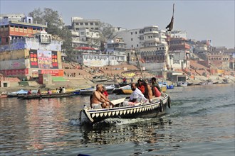 People in a boat being steered through a river by rowers, Varanasi, Uttar Pradesh, India, Asia