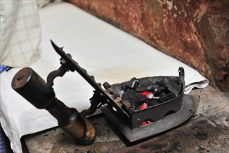Traditional charcoal iron placed on a work cloth, Varanasi, Uttar Pradesh, India, Asia