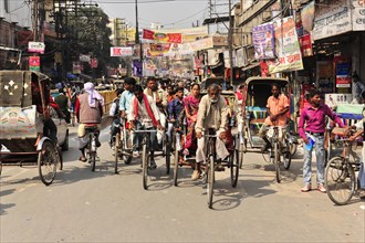 Lively street scene with cycle rickshaws and passers-by in a busy area, Varanasi, Uttar Pradesh,