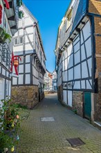 Sun-drenched alleyway with shadow effect between German half-timbered houses, Old Town, Hattingen,