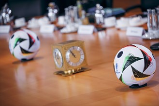 Two footballs lie on the cabinet table during a cabinet meeting at the Federal Chancellery in