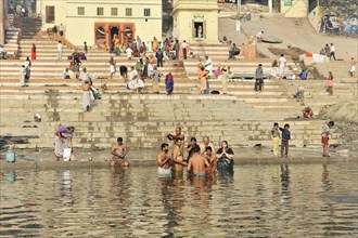 View of steps on riverbank with people performing daily ritual, Varanasi, Uttar Pradesh, India,