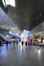Spacious interior with people and cars under a high ceiling, BMW WELT, Munich, Germany, Europe