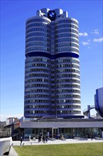 The BMW building with its striking shape and people in front of it on a sunny day, BMW WELT,