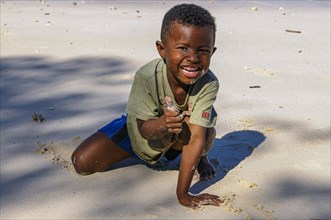 Little boy playing on a beach on the island Nosy Iranja near Nosy Be, Madagascar, Africa