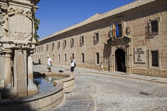 Tourists walk by the international university of andalusia and Santa Maria fountain