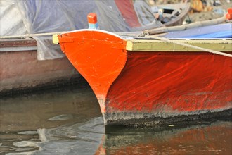 Detail of a colourful boat by the water with striking red paintwork, Varanasi, Uttar Pradesh,