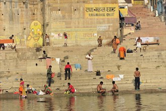 People performing ritual ablutions and prayers at the traditional ghats by the river, Varanasi,