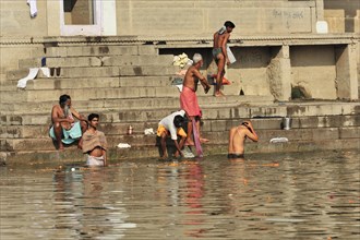 People bathing and washing at the ghats of a river in India, Varanasi, Uttar Pradesh, India, Asia