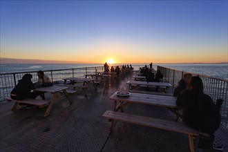 Tourists enjoying sunset on pleasure pier, Royal Pier, Cardigan Bay, Aberystwyth, Ceredigion,